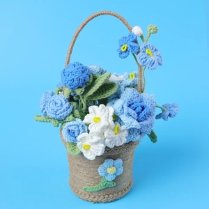 Gros plan d'un panier de fleurs crochetées à la main avec fleurs bleues et blanches et ficelle