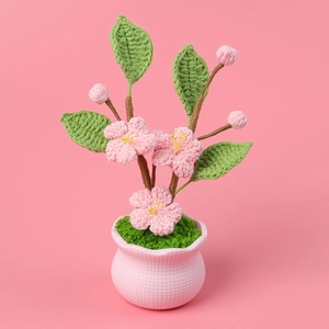 Handmade crochet peach blossom potted plant with pink flowers and ceramic base