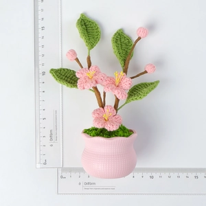 Detail showing the 14.5cm height scale of the handmade crochet peach blossom flower pot