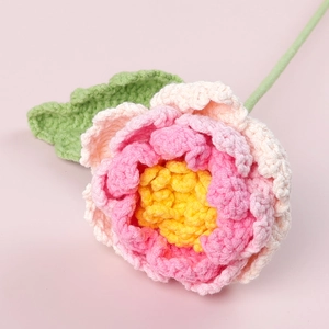 Vue détaillée d'une pivoine faite main au crochet avec pétales roses en dégradé de fils