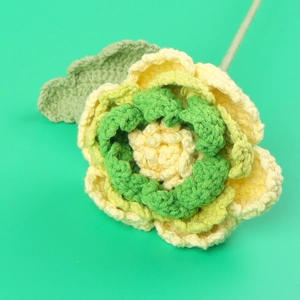 Détail macro d'une pivoine faite main au crochet avec pétales jaunes et tige verte
