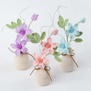 Detailed view of hand-knitted crochet clematis pots in purple, pink and sky blue colors