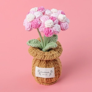 Detail of handmade crochet pink flower pot with HandMade WITH LOVE label on soft pink background