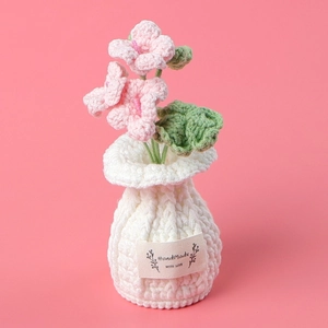 Detailed close-up of a handmade crochet pink orchid with a woven base and craft label