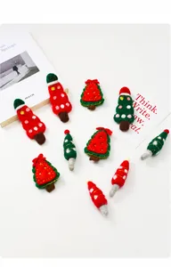 Macro detail of handmade wool felt Christmas ornaments featuring festive trees and Santa