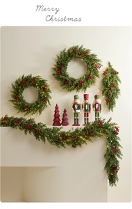 Détail d'une couronne de Noël en PE avec baies rouges et lumières LED sur cheminée