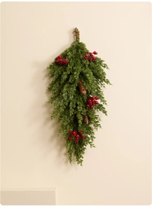 Détail d'un swag de Noël avec aiguilles de pin en PE, baies rouges et pommes de pin