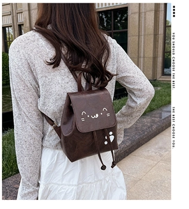 Detail of vintage brown mini backpack with cute cat embroidery on outdoor model