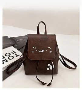 Detail of dark brown PU leather mini backpack with cute white cat face and paw print