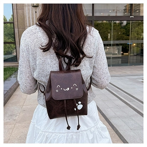 Detailed view of brown cat-themed backpack with cute ear design and leather texture