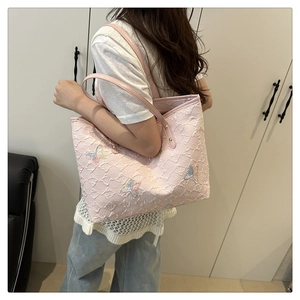 Close-up of pink quilted tote bag with colorful butterfly embroidery and spacious design