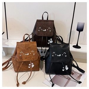 Detail of cute cat-themed mini leather backpacks with drawstring closure in three colors