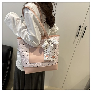 Gros plan sur un sac cabas rose matelassé avec garniture en cuir et accessoire foulard en soie