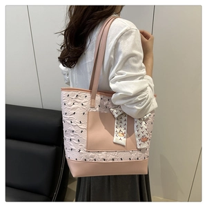 Détail du sac cabas rose chic avec broderie et foulard décoratif en soie sur la bandoulière