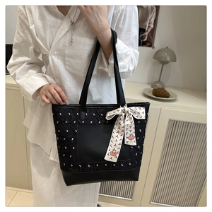 Détail du sac cabas matelassé noir avec broderie en Y et foulard en soie décoratif