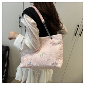 Pink tote bag detail with butterfly embroidery and silver chain leather strap