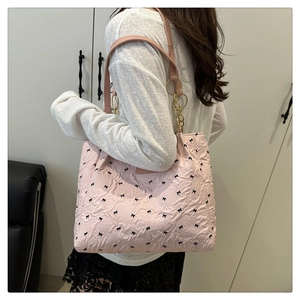 Pink quilted floral tote bag with tiny black bows and golden chain strap detail