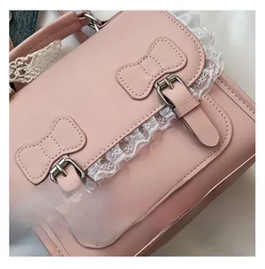 Détail du sac à dos en cuir rose avec bordure en dentelle blanche et boucles nœuds