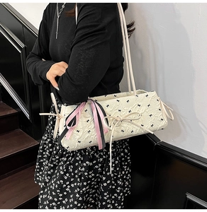 Dettaglio della borsa jacquard bianca con ricami a fiocco nero e nastri di seta rosa