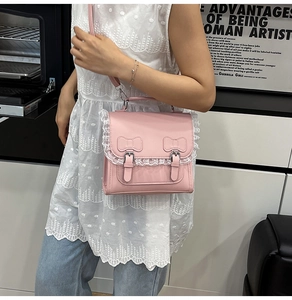 Détail du sac en cuir rose avec des nœuds mignons et des finitions en dentelle blanche