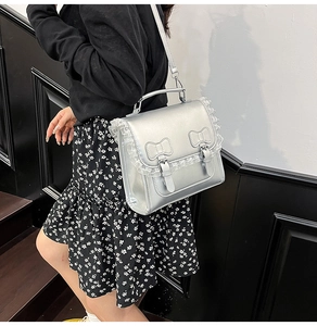 Sac à main argenté avec bordure en dentelle et nœuds décoratifs sur fond moderne