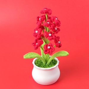 Handmade crochet red flower potted plant with white pearl stamens on red background
