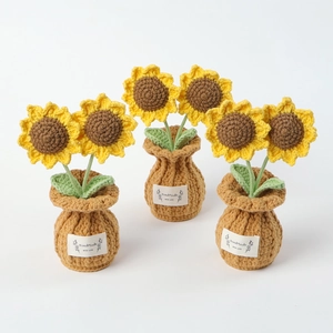 Three handmade crochet sunflower potted plants with white labels and green leaves