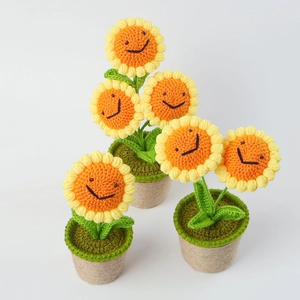 Detail of handcrafted crochet sunflower potted plants with yellow petals and smiling faces