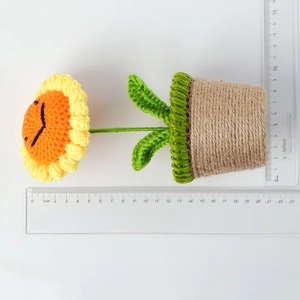 Size reference of handmade crochet sunflower plant with rulers showing 15cm height
