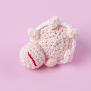 Handmade crochet mini turtle plush doll with detailed pink and white knitted textures