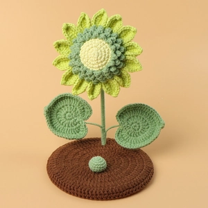 Handmade crochet sunflower phone stand with green leaves and a round wool yarn base