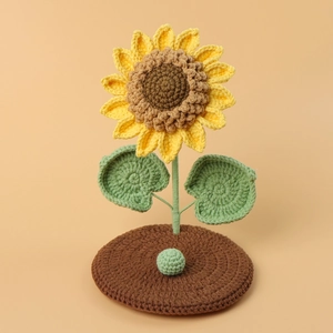 Handmade crochet sunflower phone holder stand with a stable brown knitted base for desk