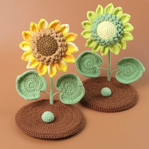 Detailed knit texture of handmade crochet sunflower phone stands in warm autumn tones