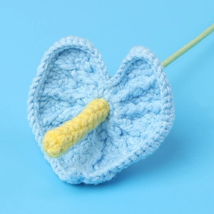 Detailed view of handmade crochet anthurium flower with intricate knitted blue heart petals