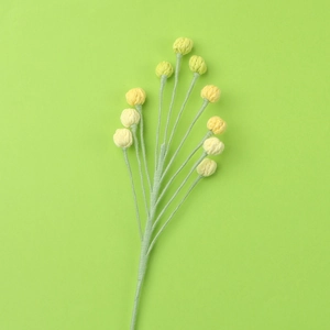 Macro detail of handmade crochet flower stem with yellow buds and green texture