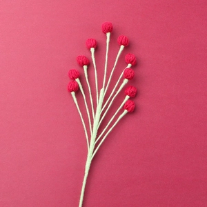 Detail of handmade crocheted red berry bouquet branches for home decoration and floral display