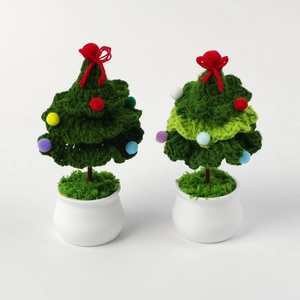 Detail of two handmade crochet Christmas tree potted plants with colorful pom-poms