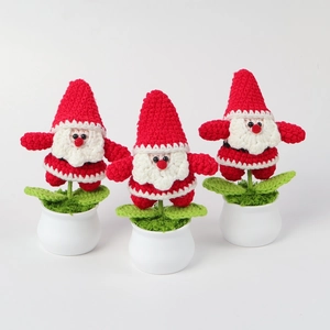 Vista dettagliata di tre piante in vaso a forma di Babbo Natale fatte a mano all'uncinetto