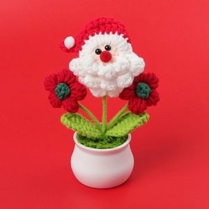 Hand-crocheted Santa Claus potted ornament with red flowers in a white ceramic vase