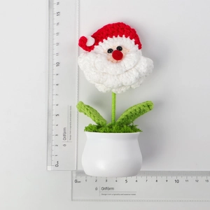 Detail of a 12.5cm handmade crochet Santa Claus potted ornament with measurement rulers