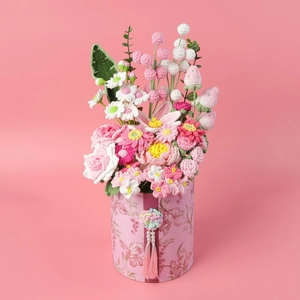 Detalle de flores y fresa hechas a mano en caja floreada con borla rosa