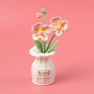 Handmade crochet orchid potted plant with pink petals and white handmade label