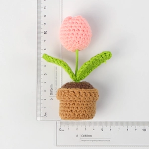 Top view of handmade pink crochet tulip plant with rulers showing 12cm height