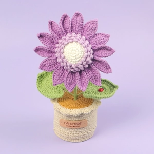 Detail of purple crochet sunflower with ladybug and handmade leather label on base
