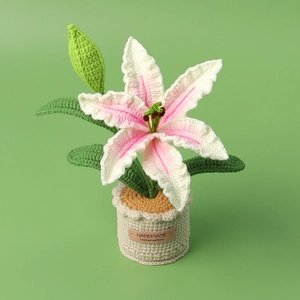 Handmade crochet lily potted plant with pink petals and green leaves in a beige pot