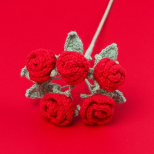 Détail de cinq roses rouges au crochet faites à la main avec feuilles et texture