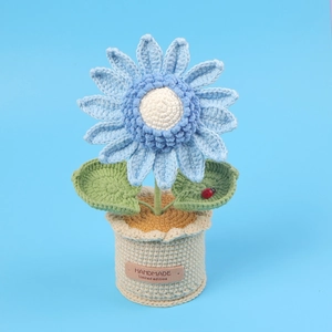 Close-up of handmade crochet sunflower pot with ladybug detail and handmade leather label