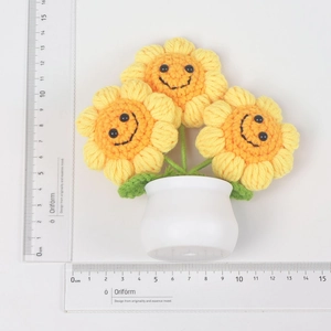 Top view of handmade crochet sunflower pot with smiling faces and detailed knit textures