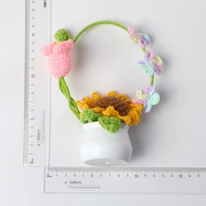 Détail d'un panier de tournesols et tulipes au crochet dans un vase en céramique