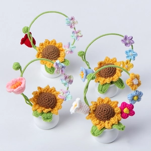 Gros plan d'un pot de tournesol au crochet avec fleurs tricotées et perles